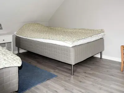 a bedroom with a bed in the corner of a room at 9 person holiday home in Åram in Sandvik
