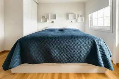 a bedroom with a bed with a blue comforter at Hus med panoramutsikt i Bud in Bud