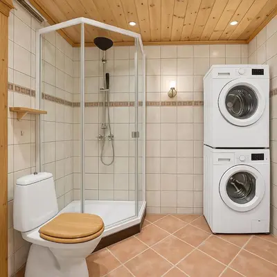 a bathroom with a toilet and a washer and dryer at Hus med panoramutsikt i Bud in Bud