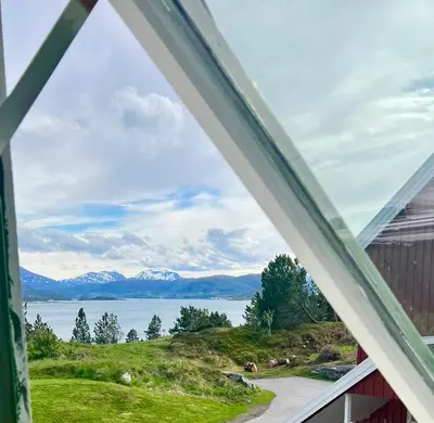 a window view of a lake and mountains at Vintage apartment with fresh sea air and pets in Kristiansund