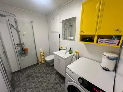 a bathroom with a sink and a washing machine at Vintage apartment with fresh sea air and pets in Kristiansund