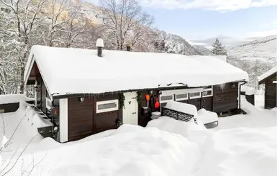 a snow covered cabin with snow on the roof at 3 Bedroom Amazing Home In Tysse in Tysse