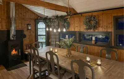 a dining room with a wooden table and a fireplace at 3 Bedroom Amazing Home In Tysse in Tysse