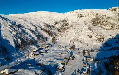 a snow covered mountain with cars parked on a road at 3 Bedroom Amazing Home In Tysse in Tysse