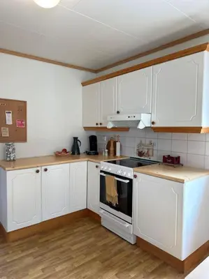 a kitchen with white cabinets and a stove top oven at Hus med panorama utsikt in Måløy
