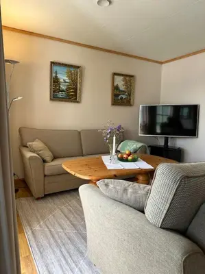 a living room with a couch and a table at Hus med panorama utsikt in Måløy