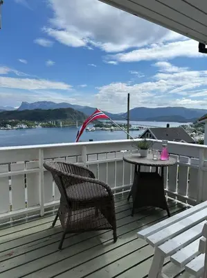 a patio with a table and chairs on a deck at Hus med panorama utsikt in Måløy