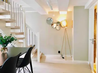 a dining room with a table and chairs and a staircase at Very Central Beautiful Modern Apartment in Bergen
