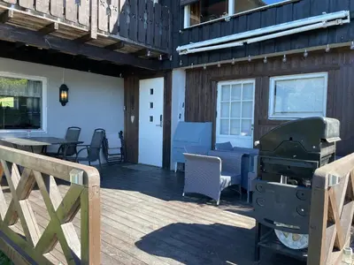 a grill on the deck of a house at Hyggelig og velutstyrt leilighet i Lom sentrum in Lom