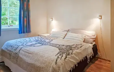 a bedroom with a bed with a bedspread with a tree on it at 2 Bedroom Nice Home In Skatval in Tilleraune