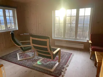 two chairs sitting on a rug in a room with windows at Perfect Couple's Hideaway In Nature! in Beitostøl