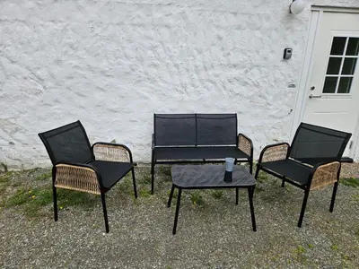 three chairs and a table in front of a building at Leilighet Vingnes in Lillehammer