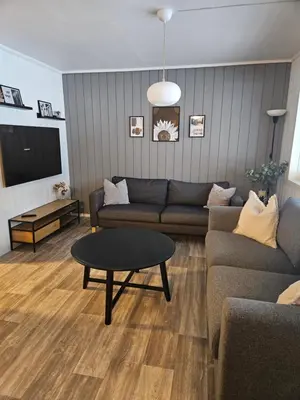 a living room with a couch and a table at Leilighet Vingnes in Lillehammer
