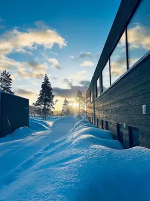 a snow covered street with the sun setting in the background at Eksklusiv hytte ved Fyri Resort - Utsikt in Hemsedal