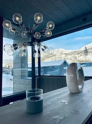 a table with a glass and a chandelier in a room at Eksklusiv hytte ved Fyri Resort - Utsikt in Hemsedal