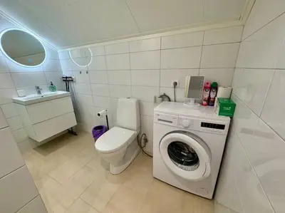 a bathroom with a toilet and a washing machine at Loft Apartment in Stranda
