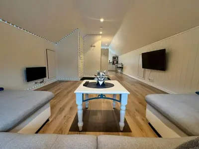 a living room with a table in the middle of a room at Loft Apartment in Stranda