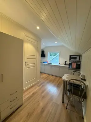 a living room with a table and a kitchen at Loft Apartment in Stranda