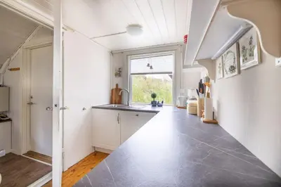 a kitchen with white walls and a large window at Peaceful cabin retreat in the Norwegian mountains in Ulsteinvik