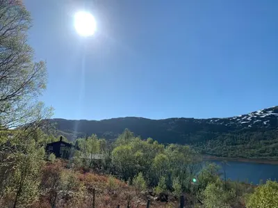 a view of a lake and a house on a hill at Peaceful cabin retreat in the Norwegian mountains in Ulsteinvik