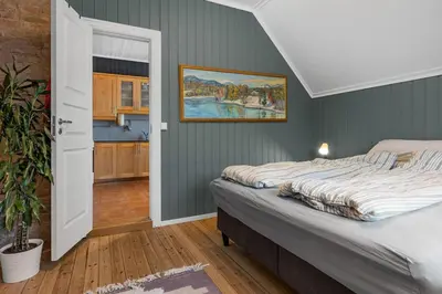 a bedroom with a bed and a painting on the wall at Sentral leilighet i klassisk hus! in Lillehammer