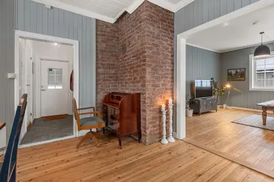 a living room with a brick wall and a fireplace at Sentral leilighet i klassisk hus! in Lillehammer