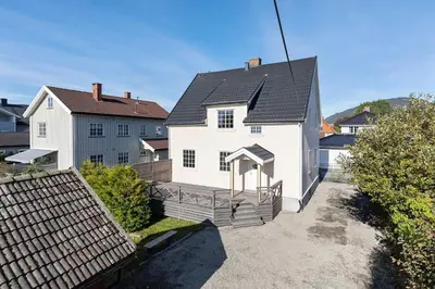 a white house with a black roof at Sentral leilighet i klassisk hus! in Lillehammer