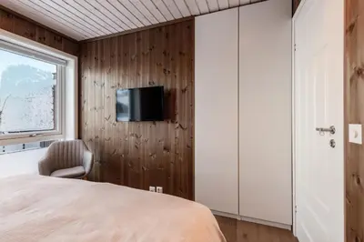 a bedroom with a bed and a tv on a wall at Leilighet på Bualie, Golsfjellet in Gol