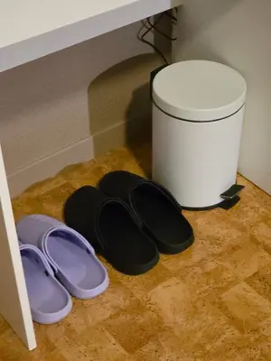 two pairs of flip flops on the floor next to a trash can at Rom 6 sentralt i Sogndal in Sogndal