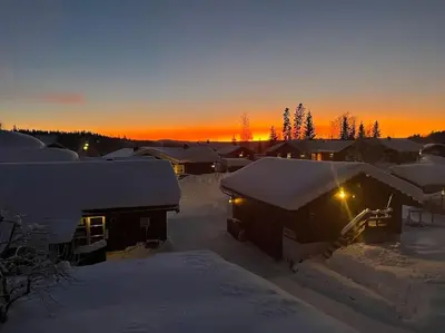 a group of houses covered in snow at sunset at Nice log house close to Lillehammer and Sjusjøen in Haugen