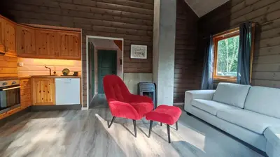 a living room with red chairs and a couch at Gunnarhytta, Valevåg in Valevåg