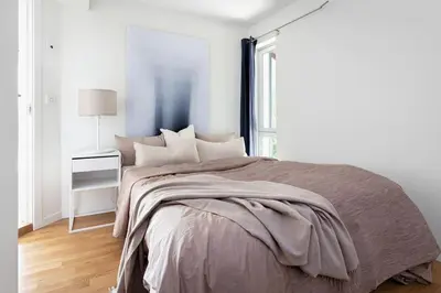 a white bedroom with a large bed and a window at 7 min to Ski Championship, Glass front house, Terrace in Trondheim