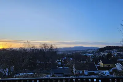 a view of a city with the sun setting at 7 min to Ski Championship, Glass front house, Terrace in Trondheim
