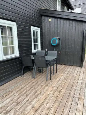 a patio with a table and chairs on a deck at Flott Leilighet i stølen oppdal for 6 personer, ski in, ski out in Oppdal