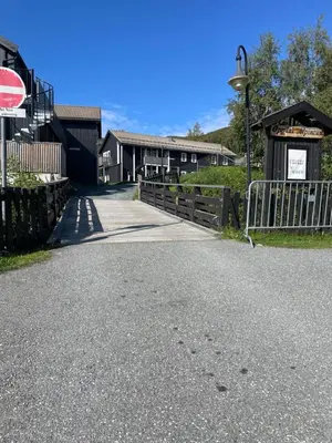 a road leading to a building with a gate at Flott Leilighet i stølen oppdal for 6 personer, ski in, ski out in Oppdal
