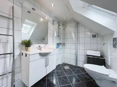 a white bathroom with a sink and a toilet at Apartment with Loft & Window Balcony, Free parking in Bergen