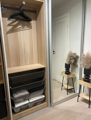 a closet with a mirror and a pile of towels at Plaza Havstad in Trondheim