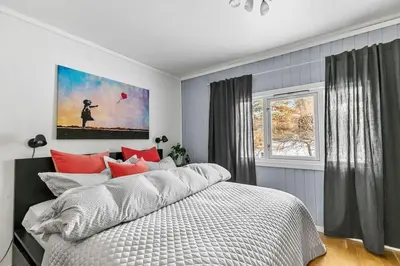 a bedroom with a large bed and a window at Villekulla - Koselig hus med jazzuci i Hamar in Hamar