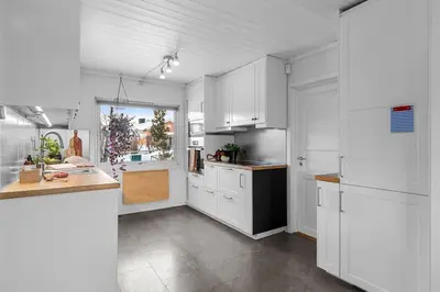 a kitchen with white cabinets and a counter top at Villekulla - Koselig hus med jazzuci i Hamar in Hamar