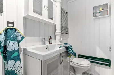 a white bathroom with a sink and a toilet at Villekulla - Koselig hus med jazzuci i Hamar in Hamar
