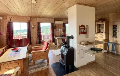 a living room with a stove in a cabin at Nice Home In Lillehammer With Sauna in Lillehammer