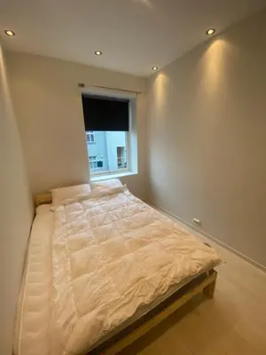 a bedroom with a large bed with a window at Moderne leilighet nær sentrum in Ålesund