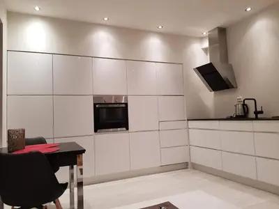 a kitchen with white cabinets and a table and a microwave at Moderne leilighet nær sentrum in Ålesund