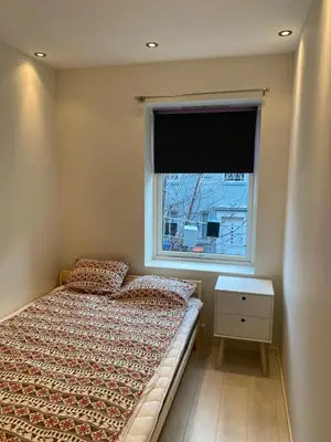 a small bedroom with a bed and a window at Moderne leilighet nær sentrum in Ålesund