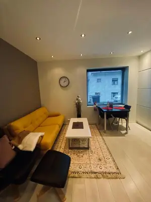 a living room with a yellow couch and a table at Moderne leilighet nær sentrum in Ålesund
