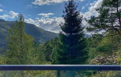 a tall pine tree in the middle of a mountain at 3 Bedroom Nice Home In Florø in Florø