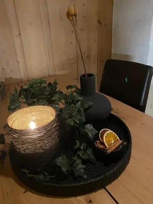 a black plate with a candle and a plant on a table at Perfect Retreat for Small Families in Beitostøl