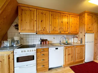 a kitchen with white appliances and wooden cabinets at Perfect Retreat for Small Families in Beitostøl