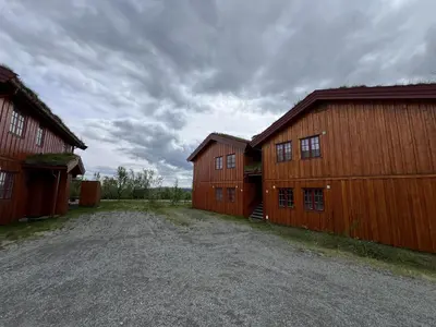 a couple of red barns with a dirt road between them at Charming 3-Bedroom Apartment With Great Views! in Beitostøl