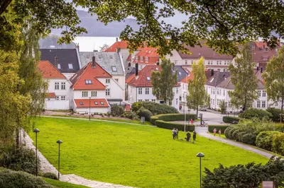 a group of people walking on a lawn in a city at Charming apartment in Sandviken in Bergen